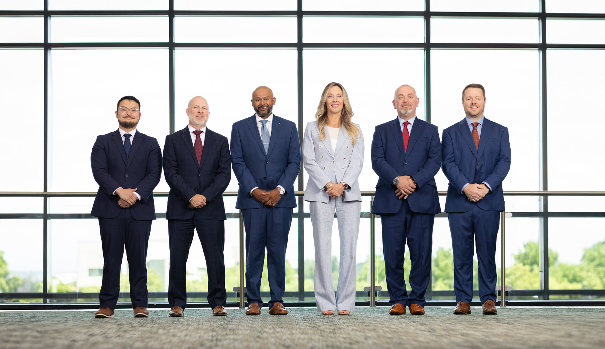 Elite Income Advisors employees standing in a line with their hands folded in front of them