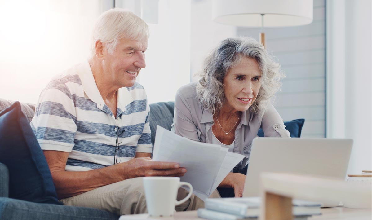 An older couple uses a laptop to plan for their retirement.