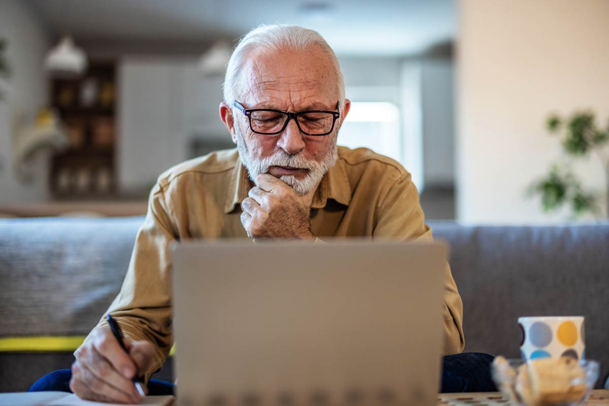 Senior at his laptop budgeting for retirement