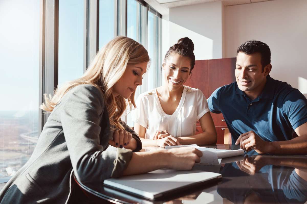 A financial advisor showing documents to a middle-aged couple.