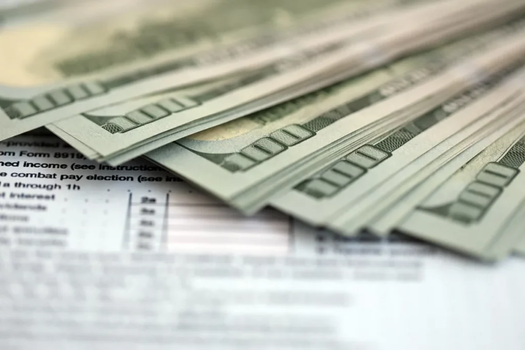 $100 bills sitting on top of a tax form representing the concept of estate tax planning methods for high net worth individuals USA