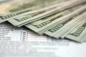 $100 bills sitting on top of a tax form representing the concept of estate tax planning methods for high net worth individuals USA