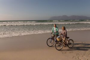 Active seniors biking on the beach in Ocean City, MD during retirement