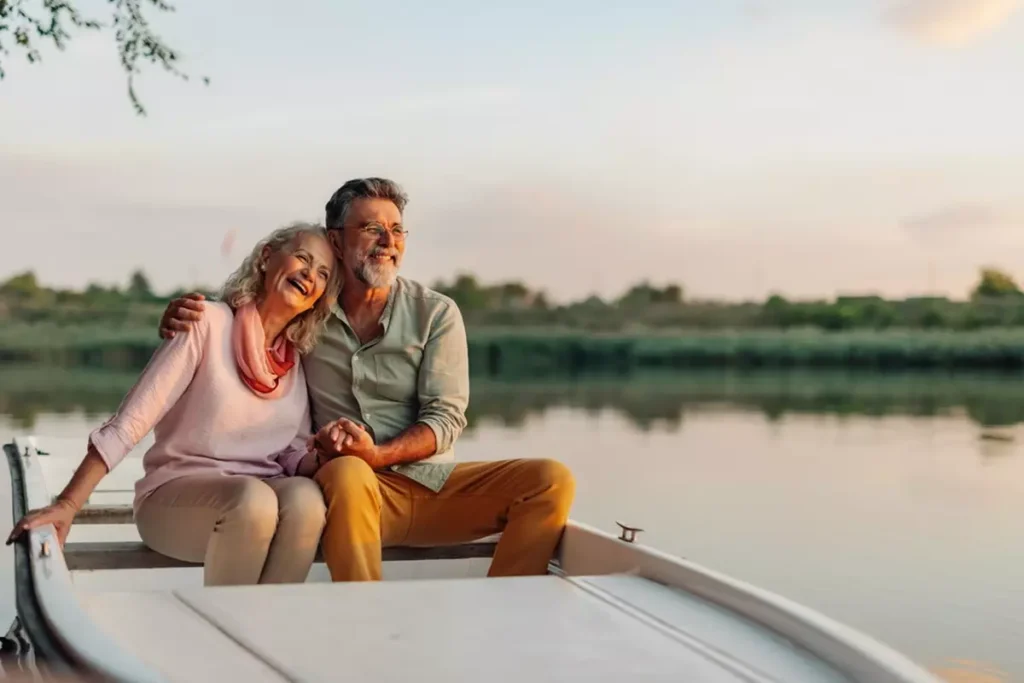 A happy retired couple sitting in a rowboat.