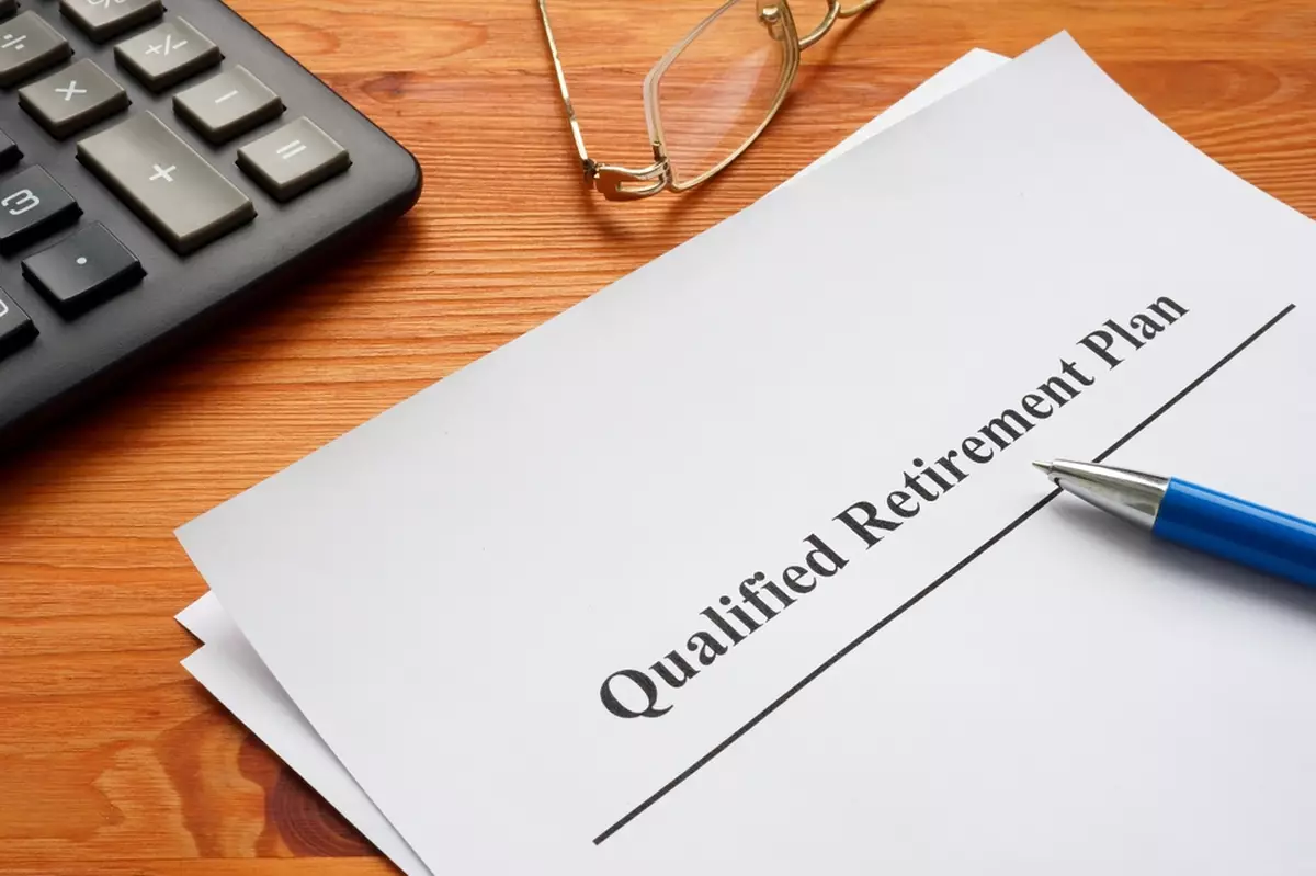 Qualified retirement plan, a calculator and glasses.