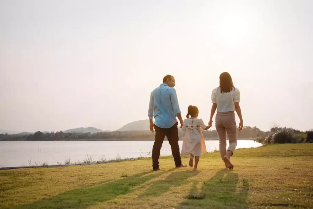 Family in park at sunset conveys the concept of life insurance and financial health
