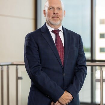 headshot of Nick with his hands folded in front of him